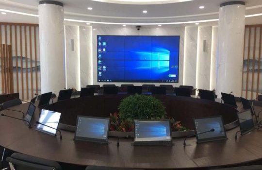 Boardroom table with monitors raised from built-in motorized lifts