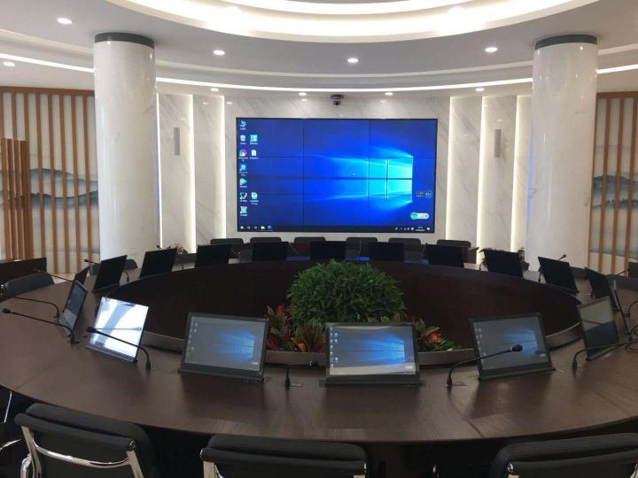 Boardroom table with monitors raised from built-in motorized lifts